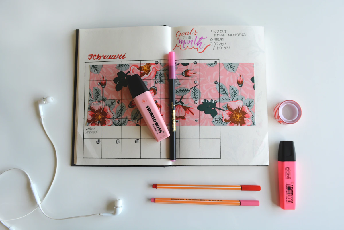 Open planner with color-coded notes and pens